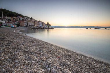 Akdeniz 'deki güzel bir köyün tarihi ufuk çizgisi, sabah kumsalda ve denizde gün doğumunda çekildi. Moenika Draga, Moscenicka Draga, Istria, Hırvatistan 'da rüya limanı manzarası