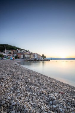 Akdeniz 'deki güzel bir köyün tarihi ufuk çizgisi, sabah kumsalda ve denizde gün doğumunda çekildi. Moenika Draga, Moscenicka Draga, Istria, Hırvatistan 'da rüya limanı manzarası