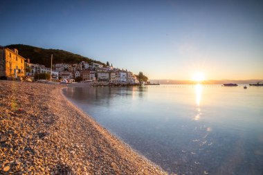 Akdeniz 'deki güzel bir köyün tarihi ufuk çizgisi, sabah kumsalda ve denizde gün doğumunda çekildi. Moenika Draga, Moscenicka Draga, Istria, Hırvatistan 'da rüya limanı manzarası