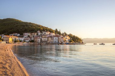 Akdeniz 'deki güzel bir köyün tarihi ufuk çizgisi, sabah kumsalda ve denizde gün doğumunda çekildi. Moenika Draga, Moscenicka Draga, Istria, Hırvatistan 'da rüya limanı manzarası