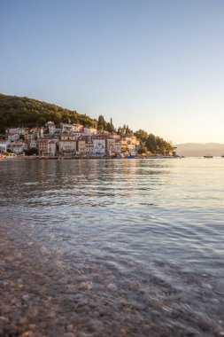 Akdeniz 'deki güzel bir köyün tarihi ufuk çizgisi, sabah kumsalda ve denizde gün doğumunda çekildi. Moenika Draga, Moscenicka Draga, Istria, Hırvatistan 'da rüya limanı manzarası