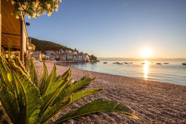 Akdeniz 'deki güzel bir köyün tarihi ufuk çizgisi, sabah kumsalda ve denizde gün doğumunda çekildi. Moenika Draga, Moscenicka Draga, Istria, Hırvatistan 'da rüya limanı manzarası