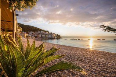 Akdeniz 'deki güzel bir köyün tarihi ufuk çizgisi, sabah kumsalda ve denizde gün doğumunda çekildi. Moenika Draga, Moscenicka Draga, Istria, Hırvatistan 'da rüya limanı manzarası