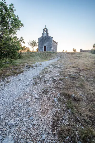 Önünde bir patika olan küçük tarihi bir kilise. Kilise, gündoğumunda ve Akdeniz manzarasında bir uçurumun üzerinde duruyor. Hırvatistan 'ın Istria kentinin tarihi Bresc köyü