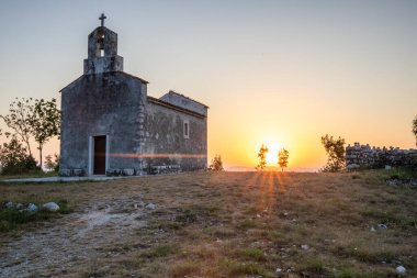 Önünde bir patika olan küçük tarihi bir kilise. Kilise, gündoğumunda ve Akdeniz manzarasında bir uçurumun üzerinde duruyor. Hırvatistan 'ın Istria kentinin tarihi Bresc köyü