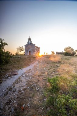 Önünde bir patika olan küçük tarihi bir kilise. Kilise, gündoğumunda ve Akdeniz manzarasında bir uçurumun üzerinde duruyor. Hırvatistan 'ın Istria kentinin tarihi Bresc köyü