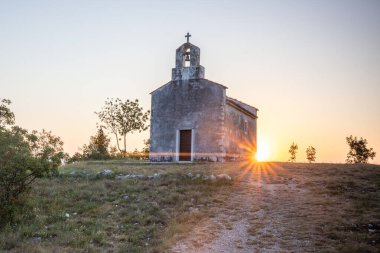 Önünde bir patika olan küçük tarihi bir kilise. Kilise, gündoğumunda ve Akdeniz manzarasında bir uçurumun üzerinde duruyor. Hırvatistan 'ın Istria kentinin tarihi Bresc köyü