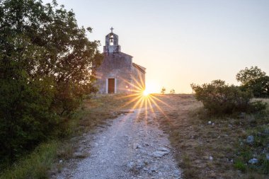 Önünde bir patika olan küçük tarihi bir kilise. Kilise, gündoğumunda ve Akdeniz manzarasında bir uçurumun üzerinde duruyor. Hırvatistan 'ın Istria kentinin tarihi Bresc köyü