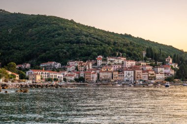 Akdeniz 'deki güzel bir köyün tarihi ufuk çizgisi, sabah kumsalda ve denizde gün doğumunda çekildi. Moenika Draga, Moscenicka Draga, Istria, Hırvatistan 'da rüya limanı manzarası