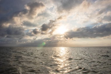 Deniz manzarası, güneşin doğduğu ufuk manzaralı bir manzara. Sanur, Bali, Endonezya 'nın kumlu sahillerinde fantastik manzara