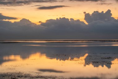 Sabahları deniz manzarası çok güzeldir. Dalgakıran ve sakin sularda gökyüzünün yansıması olan tropik kumlu bir sahil. Sanur, Bali, Endonezya