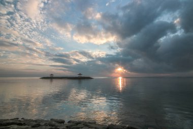 Sabahları deniz manzarası çok güzeldir. Dalgakıran ve sakin sularda gökyüzünün yansıması olan tropik kumlu bir sahil. Sanur, Bali, Endonezya