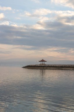 Sabahları deniz manzarası çok güzeldir. Dalgakıran ve sakin sularda gökyüzünün yansıması olan tropik kumlu bir sahil. Sanur, Bali, Endonezya