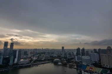 Büyük şehir silueti, şehrin ve limanın yüksek binasının manzarası. Yağmur mevsiminde günbatımı Hotel Marina Bay Sands, Singapur 'da çekildi.