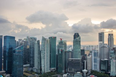 Büyük şehir silueti, şehrin ve limanın yüksek binasının manzarası. Yağmur mevsiminde günbatımı Hotel Marina Bay Sands, Singapur 'da çekildi.