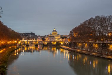 Tiber Nehri üzerinde tarihi bir şehir. Akşamları ünlü Ponte Sant 'Angelo köprüsü. Gün batımında yağmurlu hava ve Basilica di San Pietro, Roma, İtalya manzarası