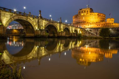 Tiber Nehri üzerinde tarihi bir şehir. Akşamları ünlü Ponte Sant 'Angelo köprüsü. Gün batımında yağmurlu hava ve Castel Sant 'Angelo, Roma, İtalya manzarası