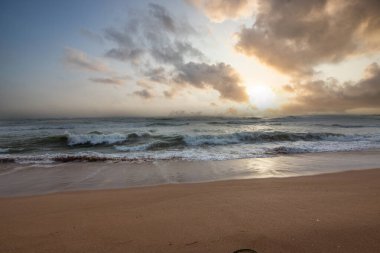 Deniz manzarası var. Ufukta deniz manzaralı uzun ve ıssız bir sahil. Kumda bir fırtınanın dalgaları kopar ve gün batımında resme özel bir dokunuş verir. Bentota, Sri Lanka, Asya