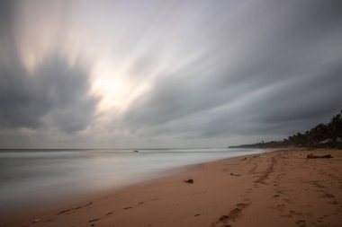 Deniz manzarası var. Ufukta deniz manzaralı uzun ve ıssız bir sahil. Kumda bir fırtınanın dalgaları kopar ve gün batımında resme özel bir dokunuş verir. Bentota, Sri Lanka, Asya