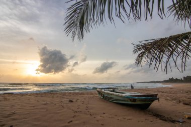 Deniz manzarası var. Ufukta deniz manzaralı uzun ve ıssız bir sahil. Kumda bir fırtınanın dalgaları kopar ve gün batımında resme özel bir dokunuş verir. Bentota, Sri Lanka, Asya