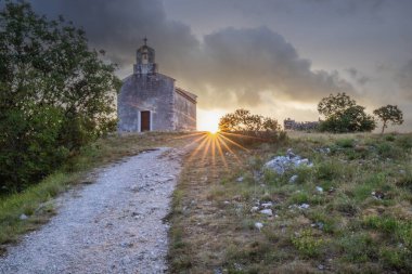 Önünde bir patika olan küçük tarihi bir kilise. Kilise, gündoğumunda ve Akdeniz manzarasında bir uçurumun üzerinde duruyor. Hırvatistan 'ın Istria kentinin tarihi Bresc köyü