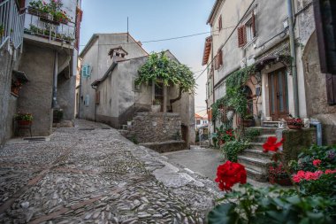 Eski, tarihi, rüya gibi dağ köyü. Dar sokaklar, romantik bir ortamda eski evler. Moenice, Moscenicka Draga, Istria, Hırvatistan küçük yolları ve meydanları olan güzel manzaralı bir yer.