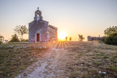 Önünde bir patika olan küçük tarihi bir kilise. Kilise, gündoğumunda ve Akdeniz manzarasında bir uçurumun üzerinde duruyor. Hırvatistan 'ın Istria kentinin tarihi Bresc köyü