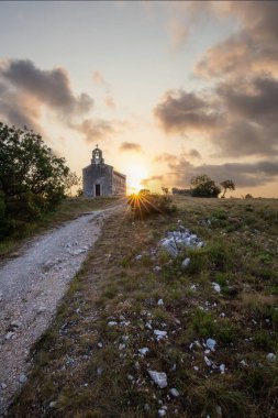 Önünde bir patika olan küçük tarihi bir kilise. Kilise, gündoğumunda ve Akdeniz manzarasında bir uçurumun üzerinde duruyor. Hırvatistan 'ın Istria kentinin tarihi Bresc köyü