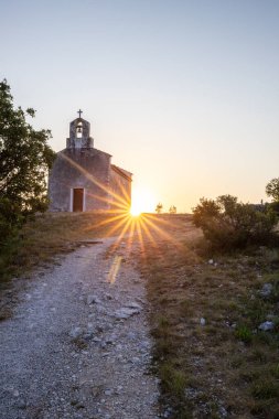 Önünde bir patika olan küçük tarihi bir kilise. Kilise, gündoğumunda ve Akdeniz manzarasında bir uçurumun üzerinde duruyor. Hırvatistan 'ın Istria kentinin tarihi Bresc köyü