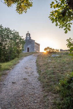 Önünde bir patika olan küçük tarihi bir kilise. Kilise, gündoğumunda ve Akdeniz manzarasında bir uçurumun üzerinde duruyor. Hırvatistan 'ın Istria kentinin tarihi Bresc köyü