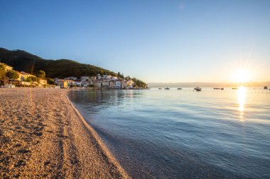 Akdeniz 'deki güzel bir köyün tarihi ufuk çizgisi, sabah kumsalda ve denizde gün doğumunda çekildi. Moenika Draga, Moscenicka Draga, Istria, Hırvatistan 'da rüya limanı manzarası