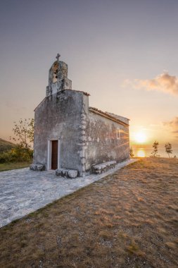 Önünde bir patika olan küçük tarihi bir kilise. Kilise, gündoğumunda ve Akdeniz manzarasında bir uçurumun üzerinde duruyor. Hırvatistan 'ın Istria kentinin tarihi Bresc köyü