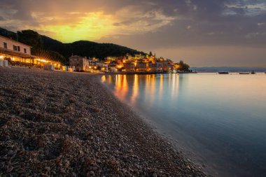 Akdeniz 'deki güzel bir köyün tarihi ufuk çizgisi, sabah kumsalda ve denizde gün doğumunda çekildi. Moenika Draga, Moscenicka Draga, Istria, Hırvatistan 'da rüya limanı manzarası