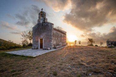 Önünde bir patika olan küçük tarihi bir kilise. Kilise, gündoğumunda ve Akdeniz manzarasında bir uçurumun üzerinde duruyor. Hırvatistan 'ın Istria kentinin tarihi Bresc köyü