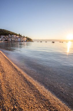 Akdeniz 'deki güzel bir köyün tarihi ufuk çizgisi, sabah kumsalda ve denizde gün doğumunda çekildi. Moenika Draga, Moscenicka Draga, Istria, Hırvatistan 'da rüya limanı manzarası