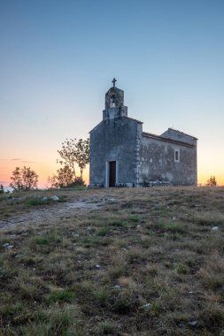 Önünde bir patika olan küçük tarihi bir kilise. Kilise, gündoğumunda ve Akdeniz manzarasında bir uçurumun üzerinde duruyor. Hırvatistan 'ın Istria kentinin tarihi Bresc köyü