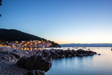 Akdeniz 'deki güzel bir köyün tarihi ufuk çizgisi, sabah kumsalda ve denizde gün doğumunda çekildi. Moenika Draga, Moscenicka Draga, Istria, Hırvatistan 'da rüya limanı manzarası