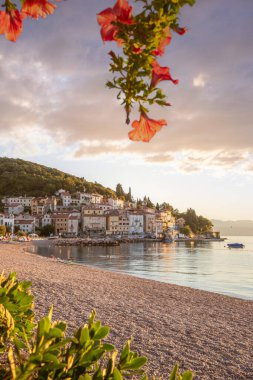 Akdeniz 'deki güzel bir köyün tarihi ufuk çizgisi, sabah kumsalda ve denizde gün doğumunda çekildi. Moenika Draga, Moscenicka Draga, Istria, Hırvatistan 'da rüya limanı manzarası