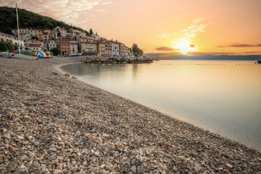 Akdeniz 'deki güzel bir köyün tarihi ufuk çizgisi, sabah kumsalda ve denizde gün doğumunda çekildi. Moenika Draga, Moscenicka Draga, Istria, Hırvatistan 'da rüya limanı manzarası