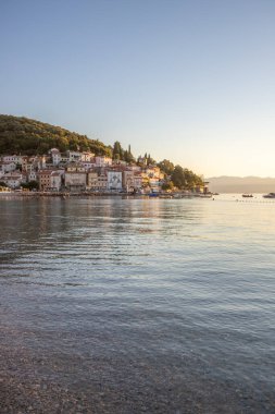 Akdeniz 'deki güzel bir köyün tarihi ufuk çizgisi, sabah kumsalda ve denizde gün doğumunda çekildi. Moenika Draga, Moscenicka Draga, Istria, Hırvatistan 'da rüya limanı manzarası