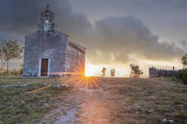 Önünde bir patika olan küçük tarihi bir kilise. Kilise, gündoğumunda ve Akdeniz manzarasında bir uçurumun üzerinde duruyor. Hırvatistan 'ın Istria kentinin tarihi Bresc köyü