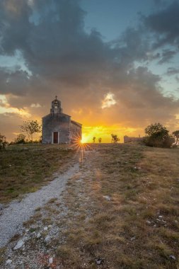 Önünde bir patika olan küçük tarihi bir kilise. Kilise, gündoğumunda ve Akdeniz manzarasında bir uçurumun üzerinde duruyor. Hırvatistan 'ın Istria kentinin tarihi Bresc köyü