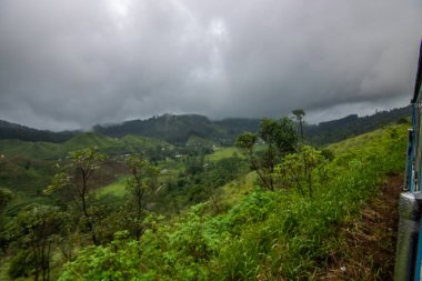 Tropikal iklimin verimli dağlık kesimlerinde manzara fotoğrafı. Orman, tarlalar ve çay tarlaları. Kandy ve Nuwara Eliya, Sri Lanka, Asya arasındaki mavi tren yolculuğu.