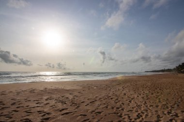 Akşama kumsalda, gün batımında. Vahşi dalgalı kumsal. Denizin üzerinde gün batımını gösteren manzara. Bentota, Sri Lanka, Asya yakınlarındaki ufuk manzarası