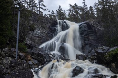 Ormandaki ve doğadaki büyük bir şelalenin manzara görüntüsü. Sonbahar manzarası Elgafossen Vattenfall nehri Vassbotten, İskandinavya 'da İsveç ile Norveç arasında doğal bir sınır oluşturur.