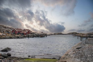 Beautiful village landscape in a fjord. Fishermen and restaurants in the evening at sunset. Boats and a beautiful landscape in Havstenssund, Sweden, Scandinavia clipart