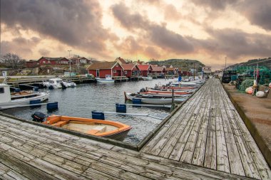 Beautiful village landscape in a fjord. Fishermen and restaurants in the evening at sunset. Boats and a beautiful landscape in Havstenssund, Sweden, Scandinavia clipart