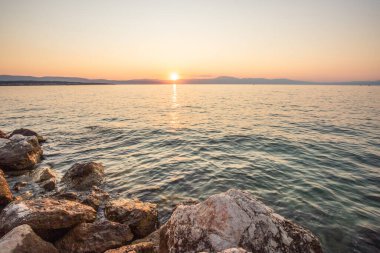 Sahil, gün batımını gören bir liman. Hırvatistan 'ın Krk kentinde deniz manzarası