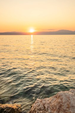 Sahil, gün batımını gören bir liman. Hırvatistan 'ın Krk kentinde deniz manzarası