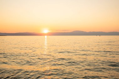 Sahil, gün batımını gören bir liman. Hırvatistan 'ın Krk kentinde deniz manzarası